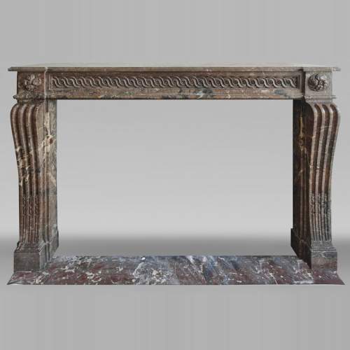 Cheminée d'époque Louis XVI galbée rouge, décorée d'une frise vitruvienne.
